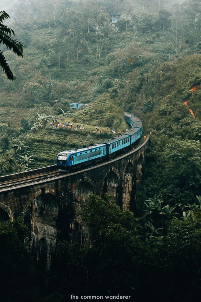 Iconic Sri Lanka blue train passing over the Nine Arch Bridge in Ella amidst lush tea hills
