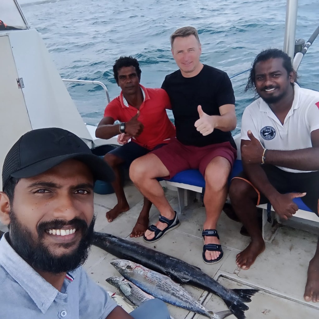 Deep sea game fishing boat excursion with happy tourist, guide and fresh ocean catch
